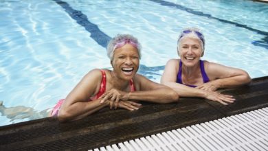 Two senior women in a swimming pool living at a senior living community that supports an active lifestyle