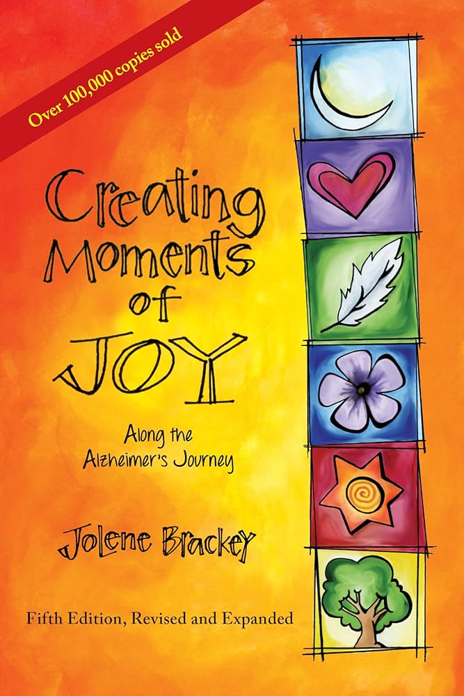 Cover of the book "Creating Moments of Joy" featuring watercolors and boxes with images of a crescent moon, heart, feather, flower, sun, and tree.
